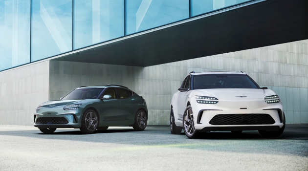 Two Genesis GV60s in front of a building